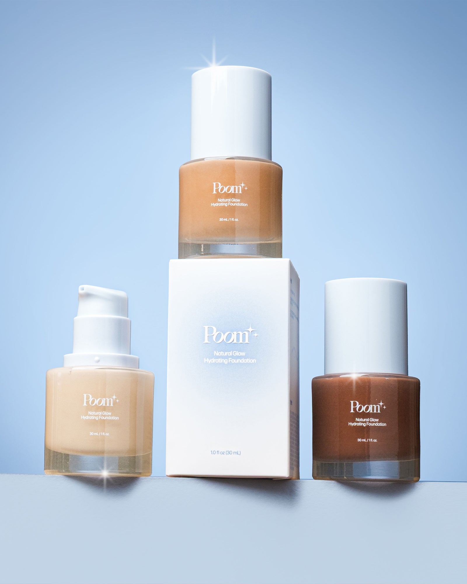Three bottles of 'Poom' foundation on a light blue background