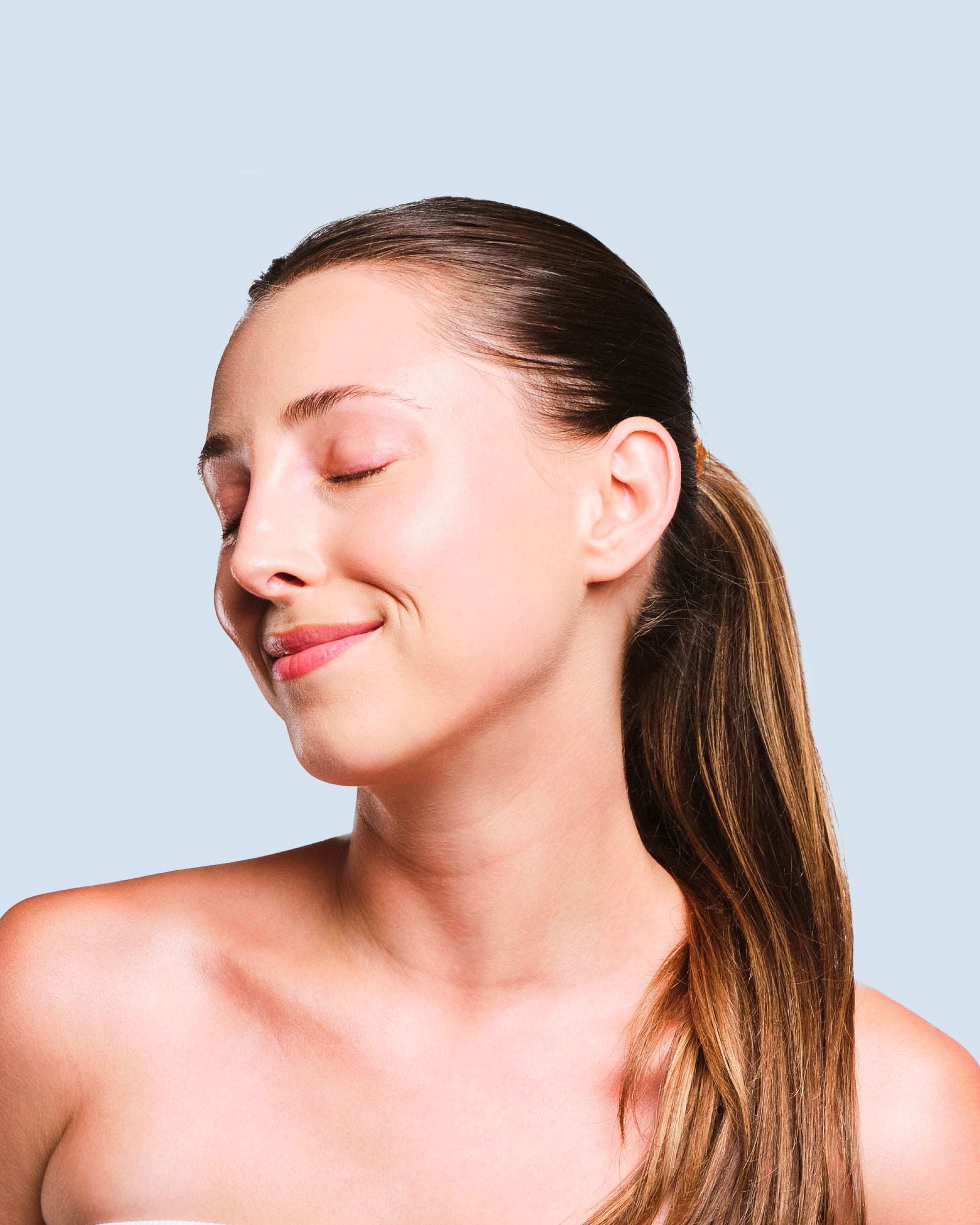Woman with a ponytail against a light blue background