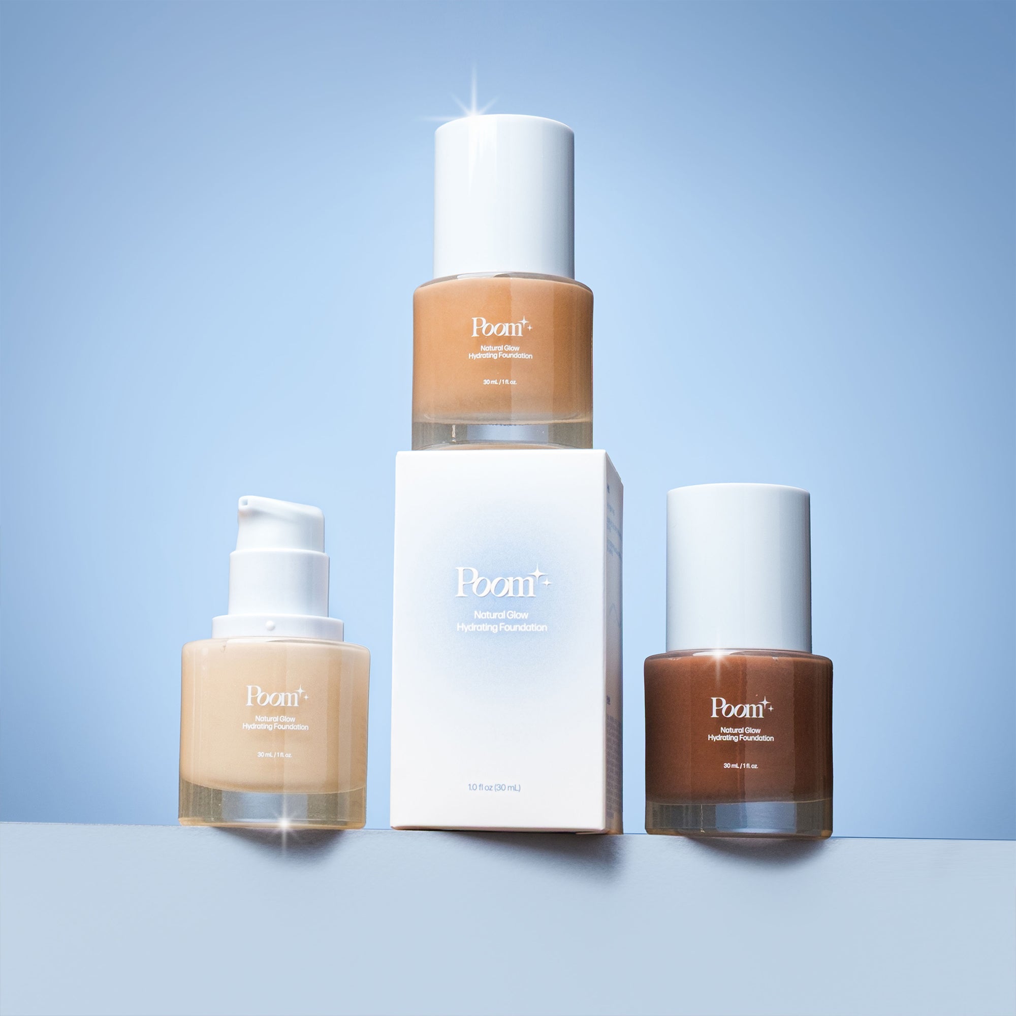 Three bottles of 'Poom' foundation on a light blue background