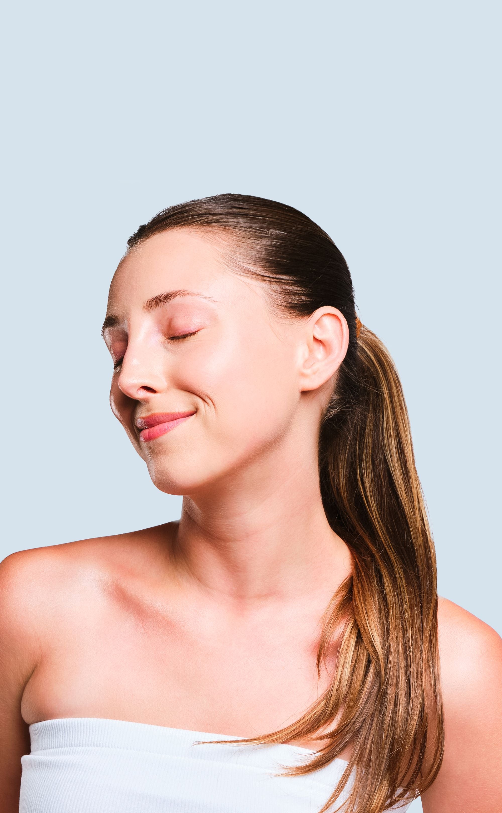 Woman with a ponytail against a light blue background